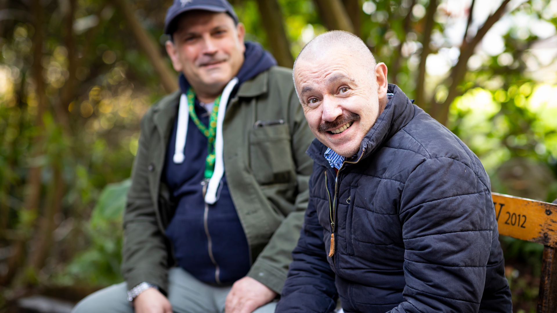Photo of two men sitting outdoors.