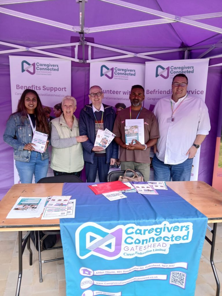 A group of volunteers proudly holding a stall at Gateshead Trinity Square.